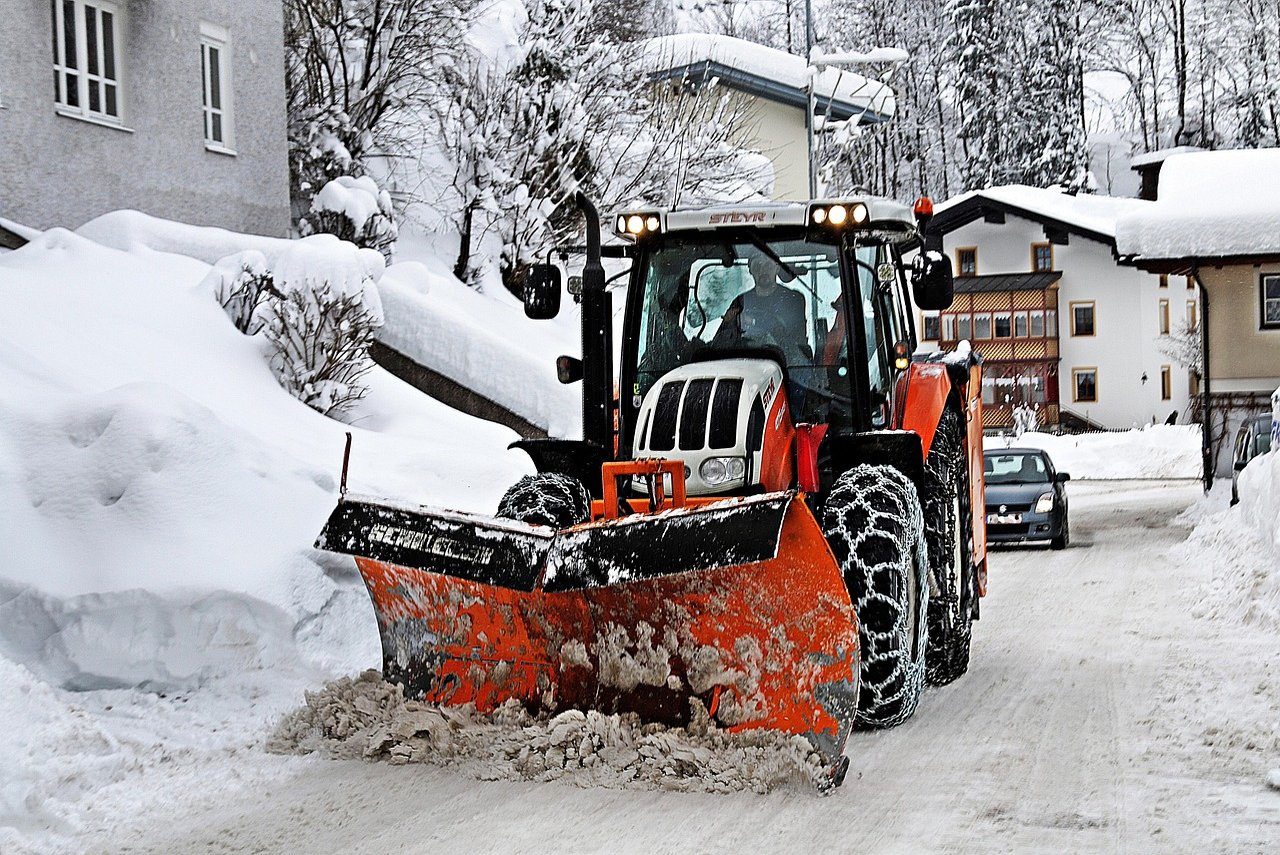 Traktor und Schneepflug im Winterdienst